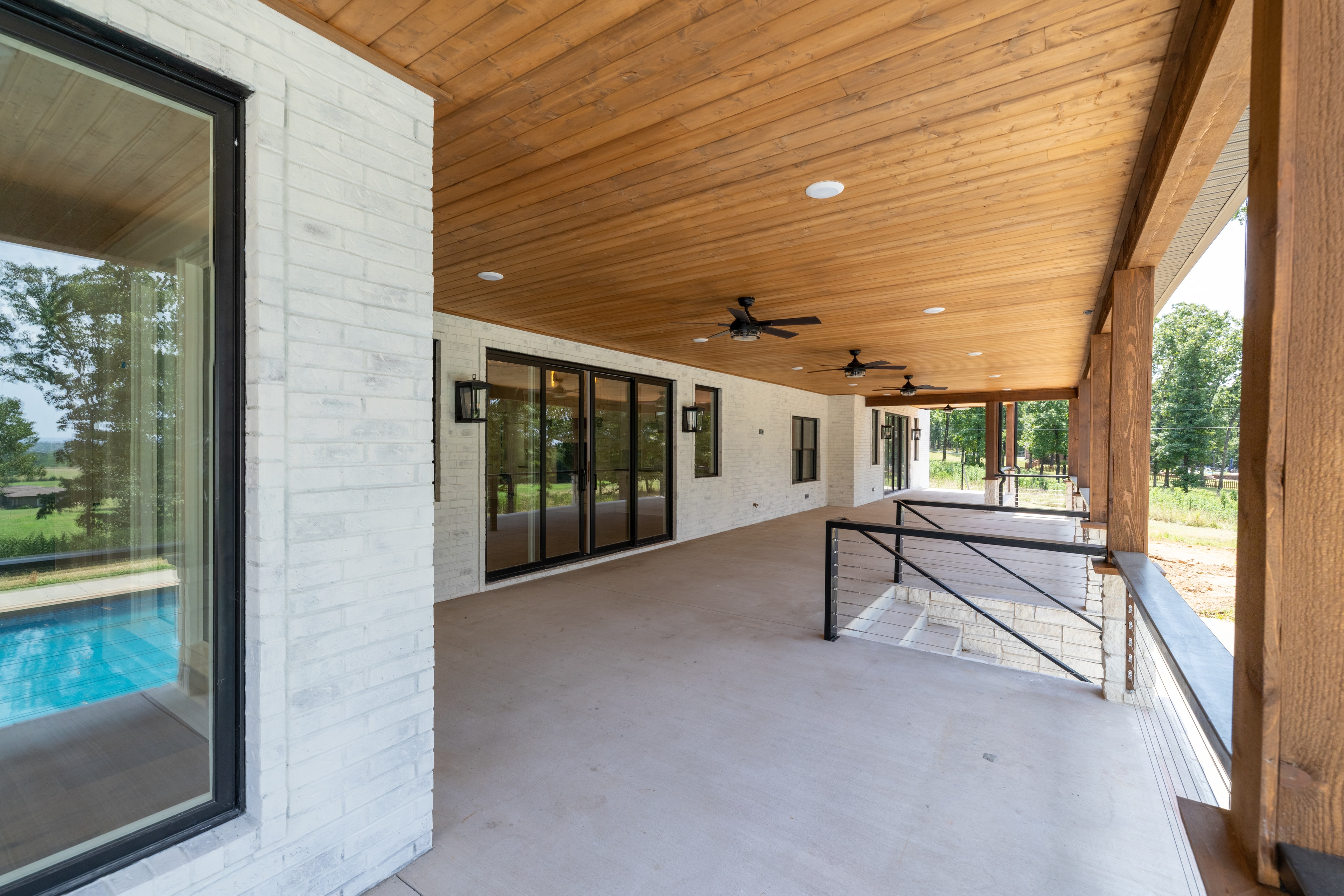 Covered patio with wood ceiling and pool view