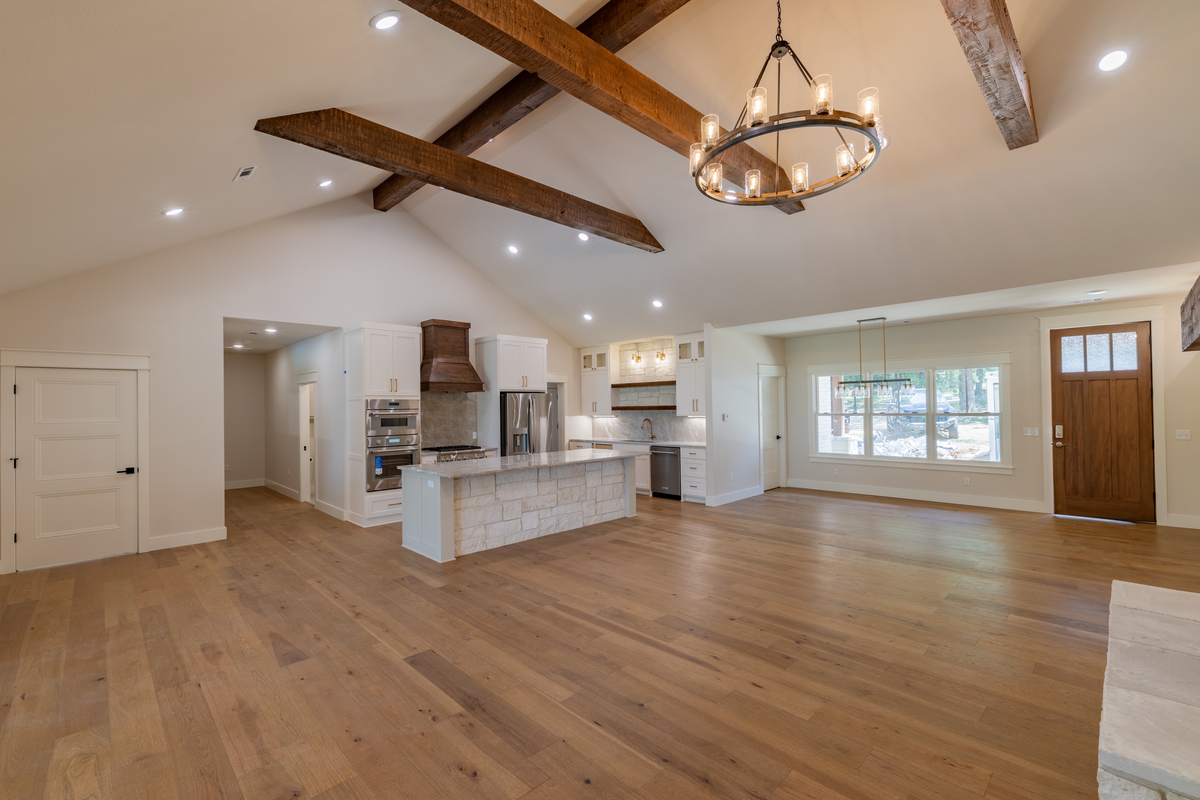 Open-concept kitchen with vaulted ceiling and wood beams